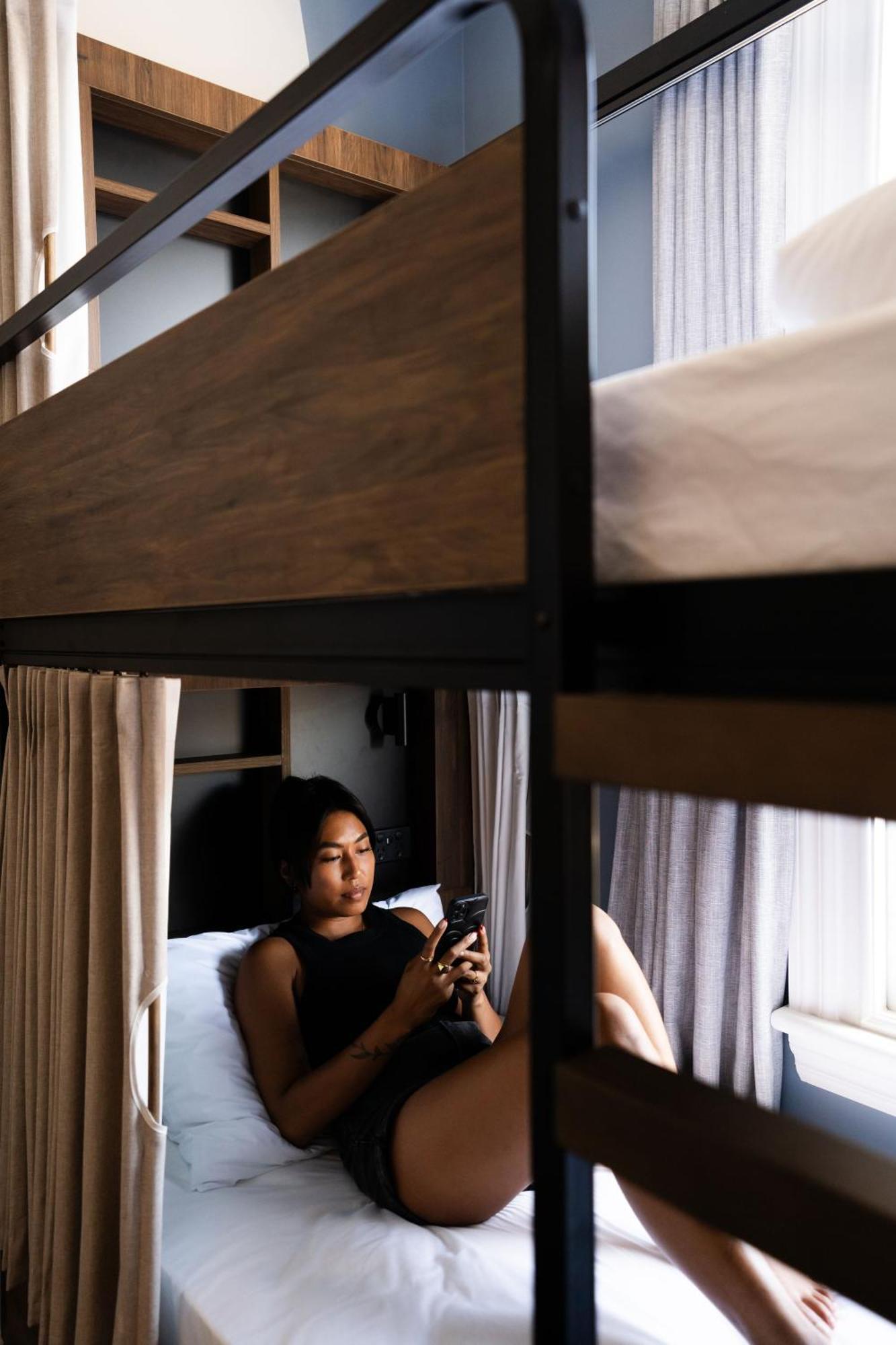 Haka House Christchurch Eksteriør bilde A woman using a mobile phone in a hostel